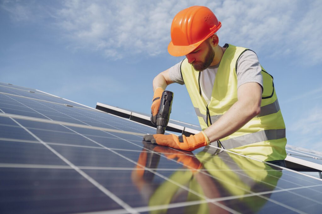 Homem parafusando placas solares para sua instalação.